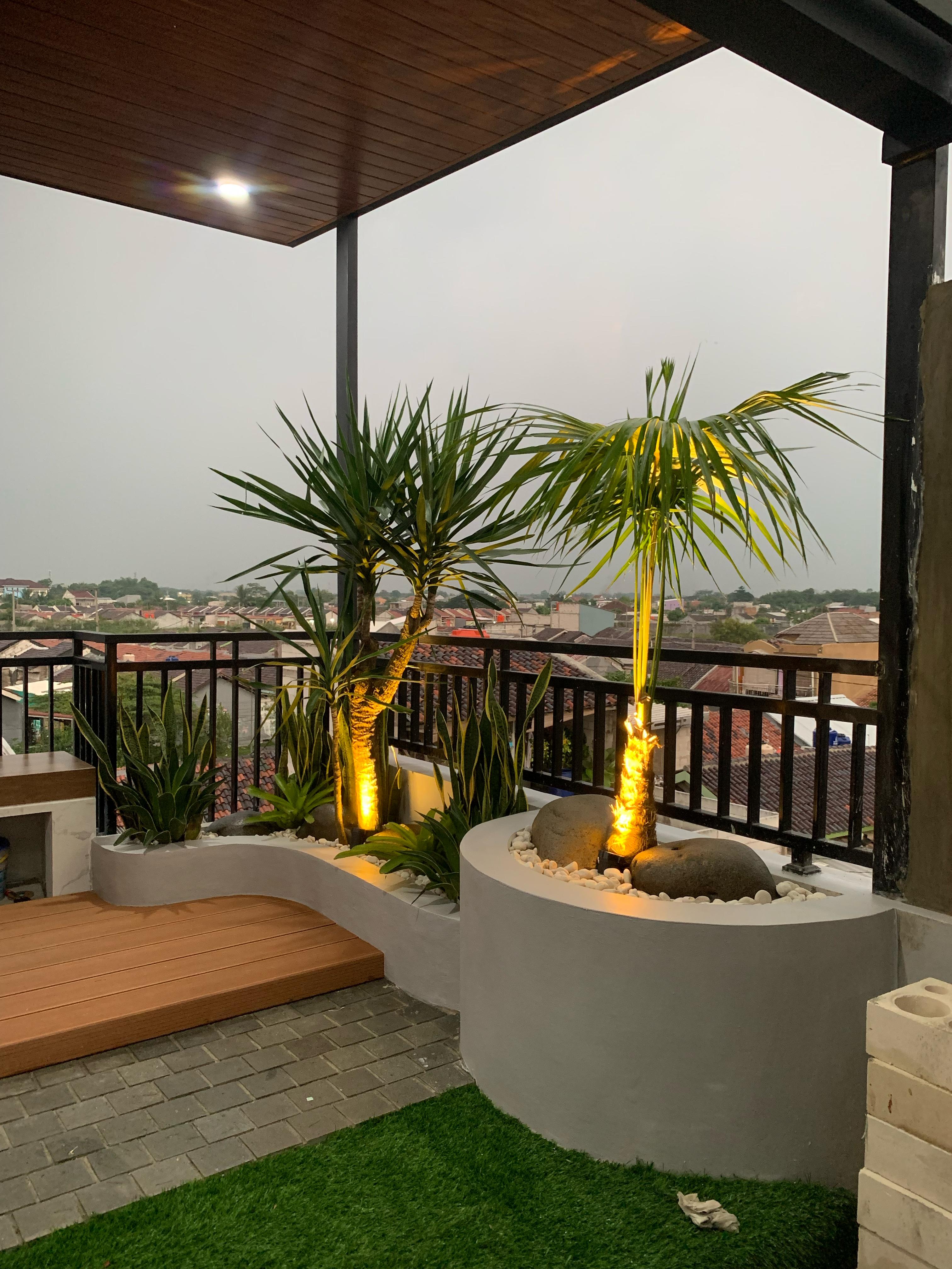 Area lounge outdoor dengan sofa besar dan meja kayu dalam suasana hangat